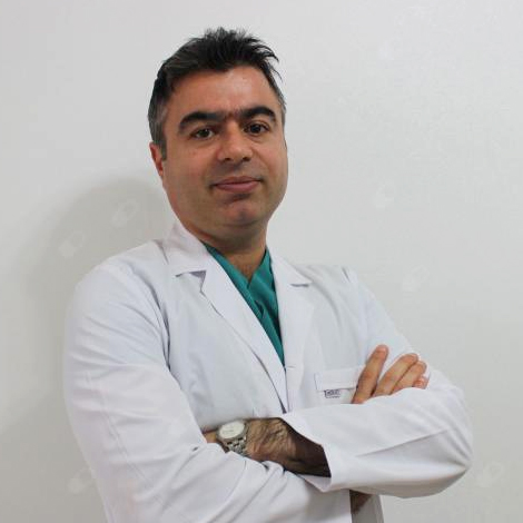 Kliniğimizden görüntü: Hekim beyaz önlükle, kollar kavuşturulmuş stüdyo portresi